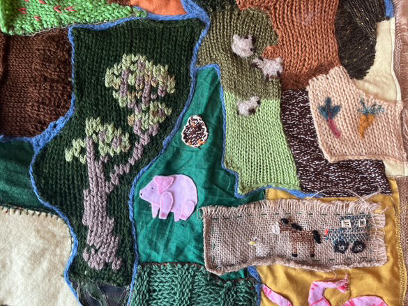 up close photograph of textile work, depicting farmland, nature and farm animals