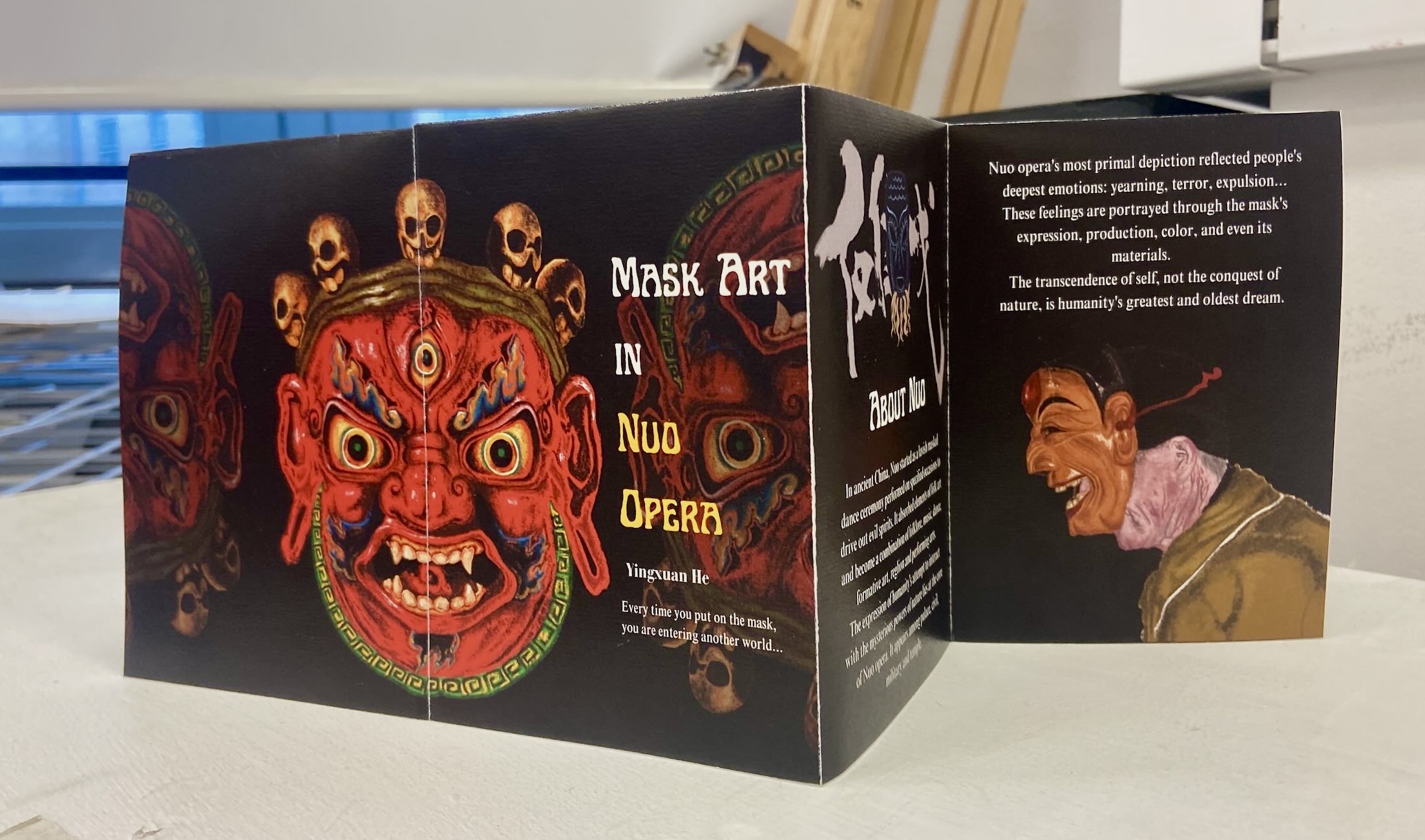 Front cover of a fold out flyer depicting traditional style East asian masks