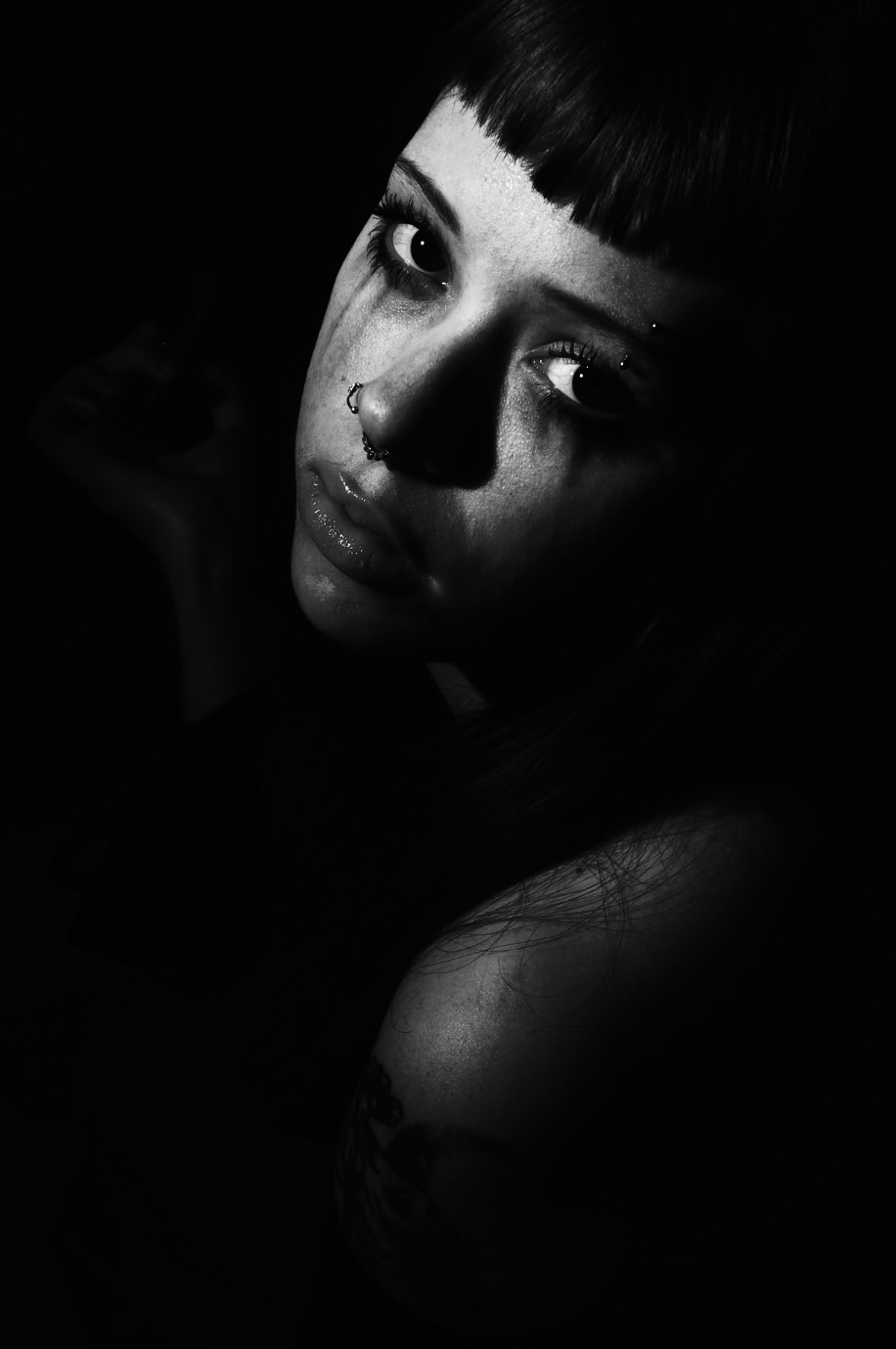 a moody, black and white portrait of a young woman crying, with her makeup smeared